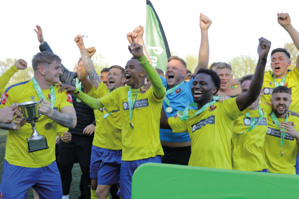 AFC Sudbury celebrating as a team with the cup for being promoted.